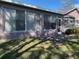 Rear exterior view of a home with a screened-in porch, bay windows, and a well-maintained yard at 11138 Brooklawn Dr, Hudson, FL 34667