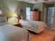 Cozy bedroom with two twin beds and a wooden dresser, creating a comfortable space at 11138 Brooklawn Dr, Hudson, FL 34667
