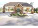 Well-maintained entrance gate with brick pillars, a garden area, and manicured landscaping at 11138 Brooklawn Dr, Hudson, FL 34667