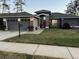Well-lit home exterior with a two-car garage and a meticulously maintained front lawn at 11138 Brooklawn Dr, Hudson, FL 34667