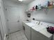 Functional laundry room with a washing machine, dryer, utility sink, and storage shelf at 11138 Brooklawn Dr, Hudson, FL 34667