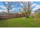 Spacious backyard with a wooden fence, mature trees, well-maintained lawn, and a stone bench at 11209 Bloomington Dr, Tampa, FL 33635
