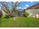 Picturesque backyard with a stone bench beneath a tree, lush lawn, and view of the screened-in pool at 11209 Bloomington Dr, Tampa, FL 33635