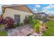 Backyard with brick patio, lush greenery, and a glimpse of the screened-in pool area at 11209 Bloomington Dr, Tampa, FL 33635