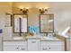 Bathroom with dual vanities, granite countertops, mirrors, and decorative lighting at 11209 Bloomington Dr, Tampa, FL 33635