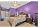 Bedroom featuring a large bed, purple walls, and a ceiling fan with lighting at 11209 Bloomington Dr, Tampa, FL 33635