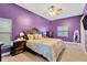 Bedroom with purple walls, a ceiling fan, and a large bed with decorative headboard at 11209 Bloomington Dr, Tampa, FL 33635