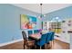 Stylish dining room with blue walls, modern chandelier, and large window at 11209 Bloomington Dr, Tampa, FL 33635