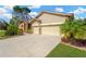 Well-maintained home featuring a two-car garage, manicured lawn, and lush landscaping at 11209 Bloomington Dr, Tampa, FL 33635