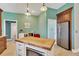 Bright kitchen featuring a wooden island countertop, stainless steel appliances, and mint green walls at 11209 Bloomington Dr, Tampa, FL 33635