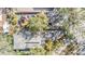 An overhead view of the property featuring a pool, patio area, and mature trees providing shade and privacy at 1157 Brook Rd, Clearwater, FL 33755