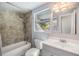 Bathroom featuring a tub with shower, toilet and vanity with neutral wall color at 1157 Brook Rd, Clearwater, FL 33755