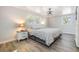 Cozy bedroom with a large window, hardwood floors, ceiling fan, and bedside tables at 1157 Brook Rd, Clearwater, FL 33755