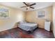 Cozy bedroom featuring wood floors, ceiling fan, and natural light at 1157 Brook Rd, Clearwater, FL 33755