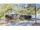 The exterior of this charming home features a covered carport and is surrounded by mature trees and landscaping at 1157 Brook Rd, Clearwater, FL 33755