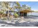 Exterior shot of a grey home with carport and manicured garden at 1157 Brook Rd, Clearwater, FL 33755