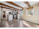 Spacious kitchen with a central island, wooden ceiling beams, stainless steel appliances, and natural light at 1157 Brook Rd, Clearwater, FL 33755