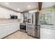 Modern kitchen with stainless steel appliances, white cabinets, light countertops, and tiled floor at 1157 Brook Rd, Clearwater, FL 33755