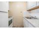 Compact kitchenette with white cabinets, marble countertop, sink, and essential appliances at 1157 Brook Rd, Clearwater, FL 33755