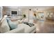 Bright and airy living room with a large TV over built-in shelves and an adjacent dining area at 1157 Brook Rd, Clearwater, FL 33755
