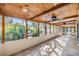 Spacious screened lanai with stone flooring and a ceiling fan at 1157 Brook Rd, Clearwater, FL 33755