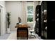 Bright home office with a sleek desk, white chair, and black shelving unit near a window at 12649 Lily Quartz Loop, Parrish, FL 34219