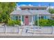 Charming home featuring a quaint picket fence, a delightful pink door, and inviting front porch chairs at 136 93Rd Ave, Treasure Island, FL 33706