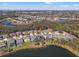 An aerial view of houses in a neighborhood, with a lake nearby, and many trees throughout the area at 13711 Moonstone Canyon Dr, Riverview, FL 33579