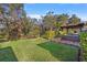 Spacious yard with lush grass, mature trees, landscaped garden, and outdoor patio at 13711 Moonstone Canyon Dr, Riverview, FL 33579