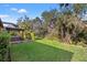 Large yard with lush grass, mature trees, landscaped garden, and outdoor patio at 13711 Moonstone Canyon Dr, Riverview, FL 33579