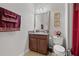 Cozy half bathroom with a wooden vanity, granite countertop, a decorative mirror, and a toilet at 13711 Moonstone Canyon Dr, Riverview, FL 33579