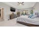 Bright bedroom featuring a ceiling fan, tile floors, and a large dresser with a flat screen TV at 13711 Moonstone Canyon Dr, Riverview, FL 33579
