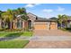 Attractive home featuring a three-car garage, stone accents, and a lush, well-maintained lawn at 13711 Moonstone Canyon Dr, Riverview, FL 33579