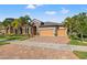 Beautiful home with a three-car garage, lush landscaping, and brick paved driveway at 13711 Moonstone Canyon Dr, Riverview, FL 33579