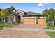 Charming home with a three-car garage, well-manicured lawn, and an appealing brick driveway at 13711 Moonstone Canyon Dr, Riverview, FL 33579
