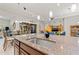 Kitchen island with modern sink, cabinets, seating, and views into the living space at 13711 Moonstone Canyon Dr, Riverview, FL 33579