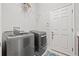 Modern laundry room with stainless steel washer and dryer, plus overhead shelving at 13711 Moonstone Canyon Dr, Riverview, FL 33579