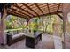 Covered outdoor patio with lighting, comfortable seating, and view of the landscaped yard at 13711 Moonstone Canyon Dr, Riverview, FL 33579