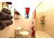 Bathroom featuring a white toilet, towels on the wall, and a red shower curtain by the bathtub at 1372 Palmetto St, Clearwater, FL 33755