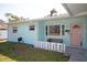 Cozy front porch featuring a cushioned bench and a charming, pastel-colored front door at 140 89Th Ne Ave, St Petersburg, FL 33702