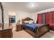 Bedroom showcasing a wooden bed frame, nightstand, closet, and red curtains at 14269 Lemon Yellow Tree Ln, Brooksville, FL 34613