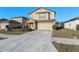 Well maintained two-story home with a two-car garage, concrete driveway, and landscaping against a clear blue sky at 14269 Lemon Yellow Tree Ln, Brooksville, FL 34613