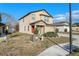 A charming two-story home with a red front door, a two car garage, and landscaping on a bright, sunny day at 14269 Lemon Yellow Tree Ln, Brooksville, FL 34613
