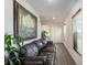 Inviting living room featuring a comfortable leather sofa, elegant artwork, and stylish wood flooring at 14269 Lemon Yellow Tree Ln, Brooksville, FL 34613