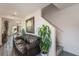 Cozy living room featuring a leather sofa, staircase, and plant, creating a comfortable and stylish atmosphere at 14269 Lemon Yellow Tree Ln, Brooksville, FL 34613