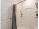 A shower area equipped with a gray curtain, multiple shelves, and a shower caddy at 14269 Lemon Yellow Tree Ln, Brooksville, FL 34613