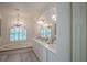 Bright bathroom featuring a soaking tub, chandelier, and double vanity with ample counter space at 16331 Burniston Dr, Tampa, FL 33647