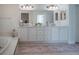 Bright and spacious bathroom with double sinks, white cabinetry, and a large mirror at 16331 Burniston Dr, Tampa, FL 33647
