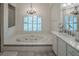Elegant bathroom with a large tub, double vanity, and natural light creating a serene atmosphere at 16331 Burniston Dr, Tampa, FL 33647