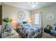 Cozy bedroom with neutral walls, patterned bedding, and a window providing natural light, complete with ceiling fan at 16331 Burniston Dr, Tampa, FL 33647